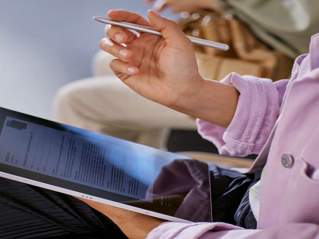 image shows woman in waiting room with digital registration on a tablet